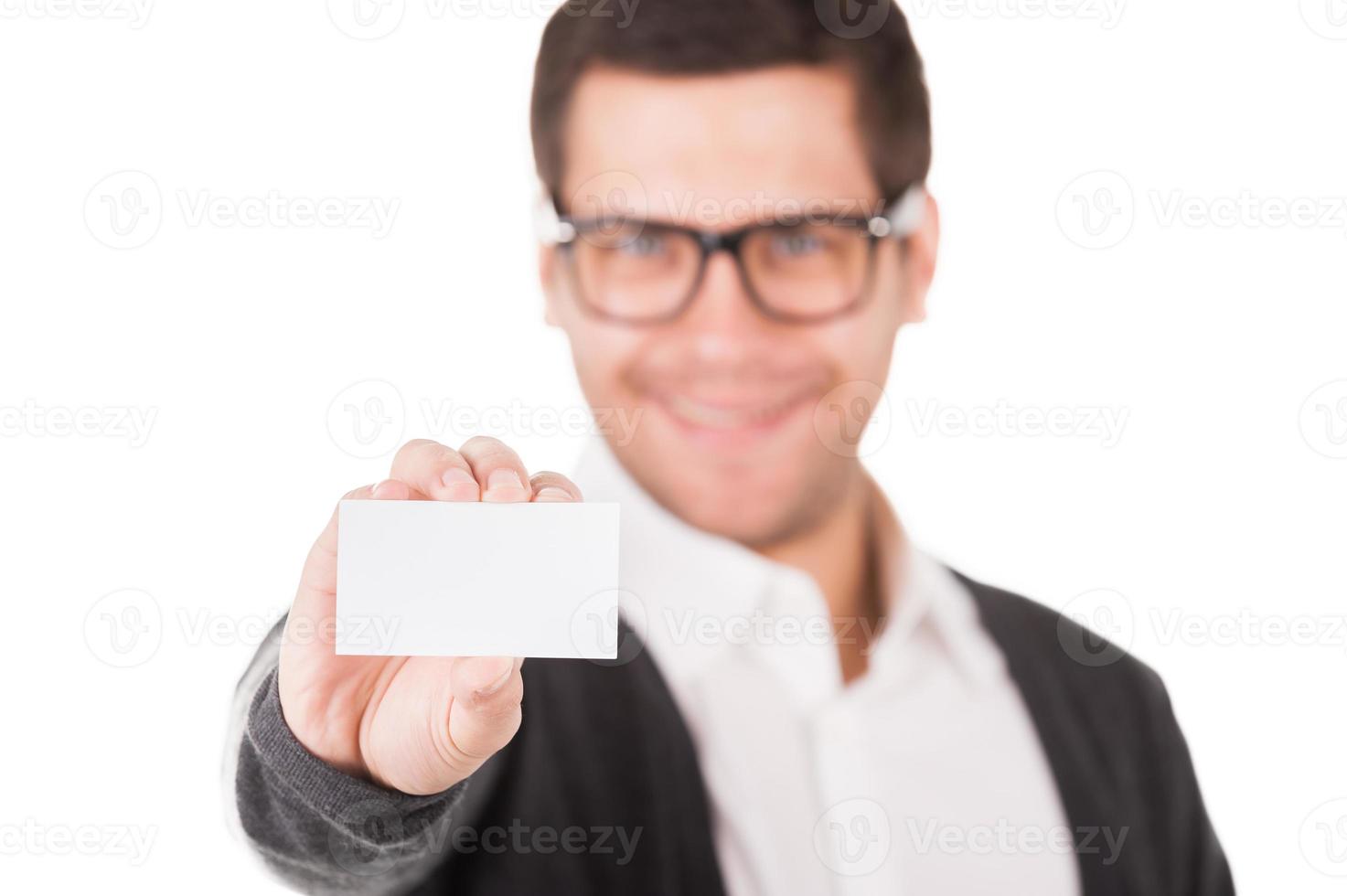 Copy space on his business card. Handsome young man stretching out hand with business card in it and smiling while standing isolated on white photo