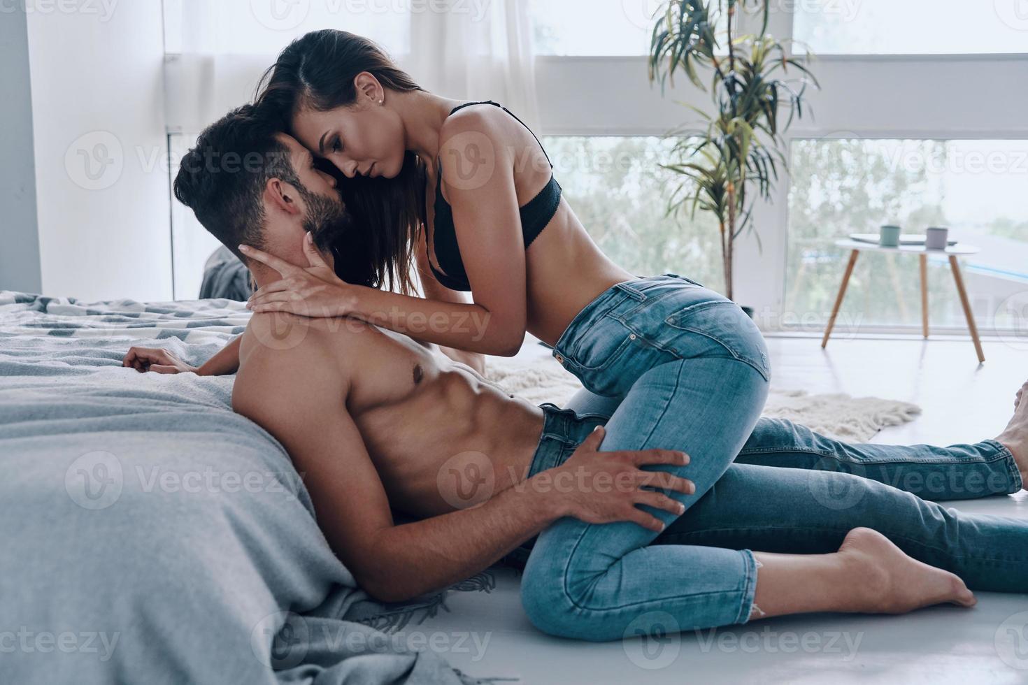 Pasión verdadera. hermosa joven pareja semi-vestida uniéndose mientras pasa tiempo en casa foto