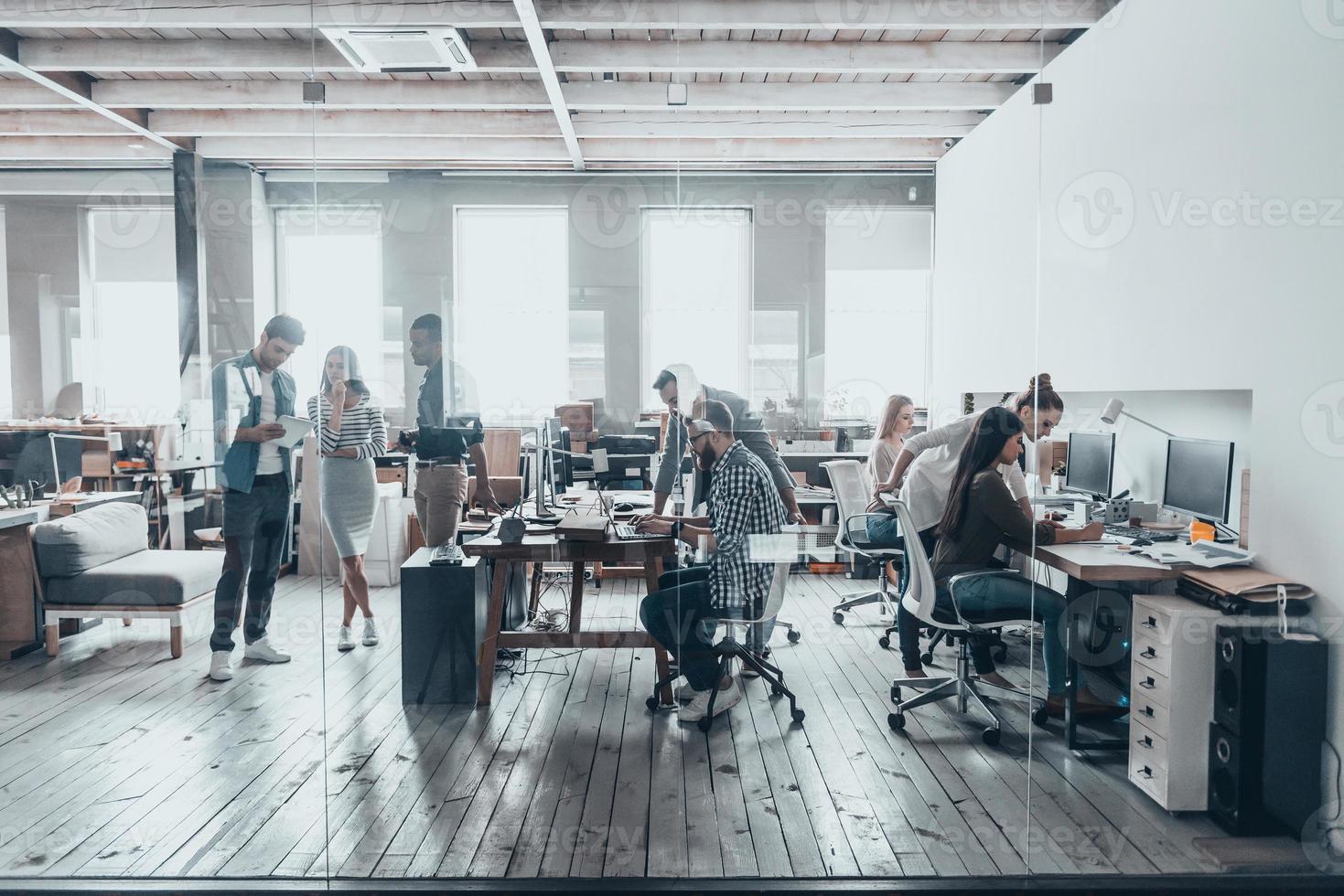 equipo en el trabajo. grupo de jóvenes empresarios con ropa informal inteligente que trabajan juntos en una oficina creativa foto