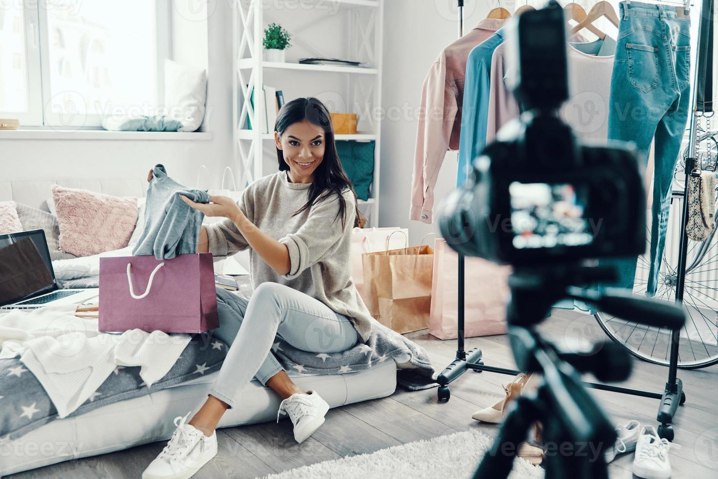 Beautiful young woman in casual clothing making social media video while spending time at home photo