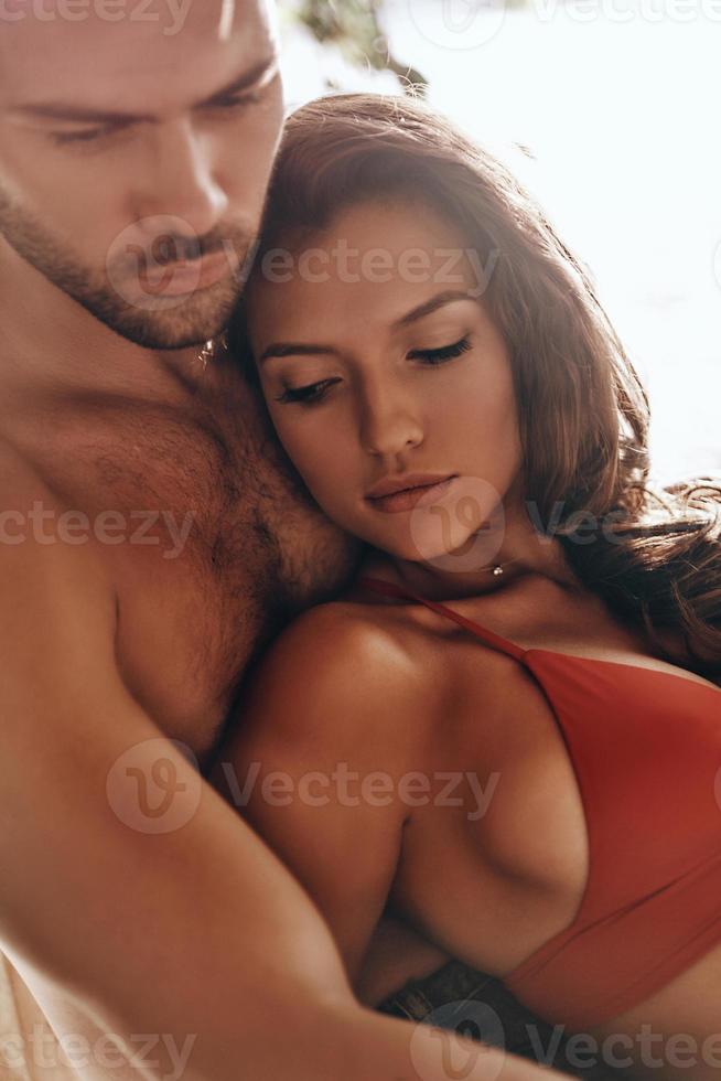 amando todo de ella. hermosa joven pareja abrazándose mientras descansa al aire libre foto