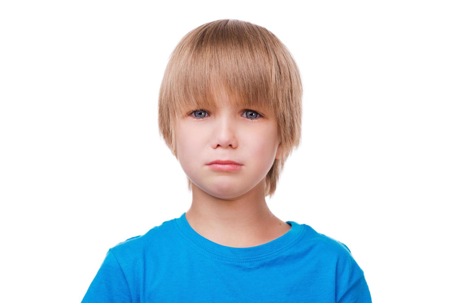 Little boy crying. Sad little boy crying and looking at camera while standing isolated on white photo