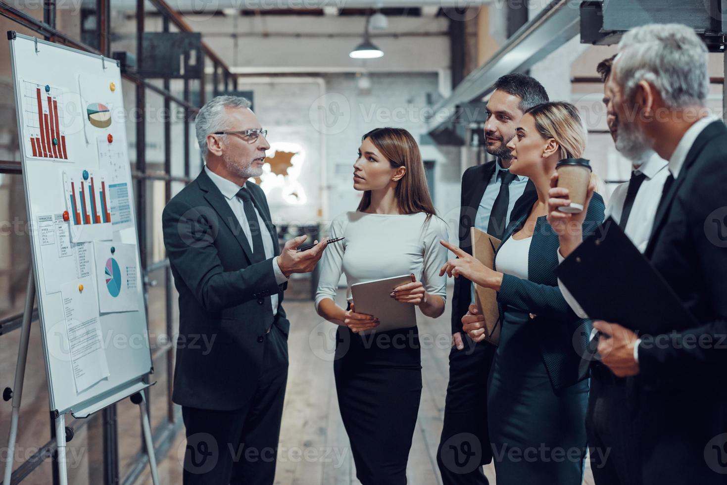 experto profesional en negocios que presenta un informe analítico mientras trabaja junto con colegas en la oficina foto