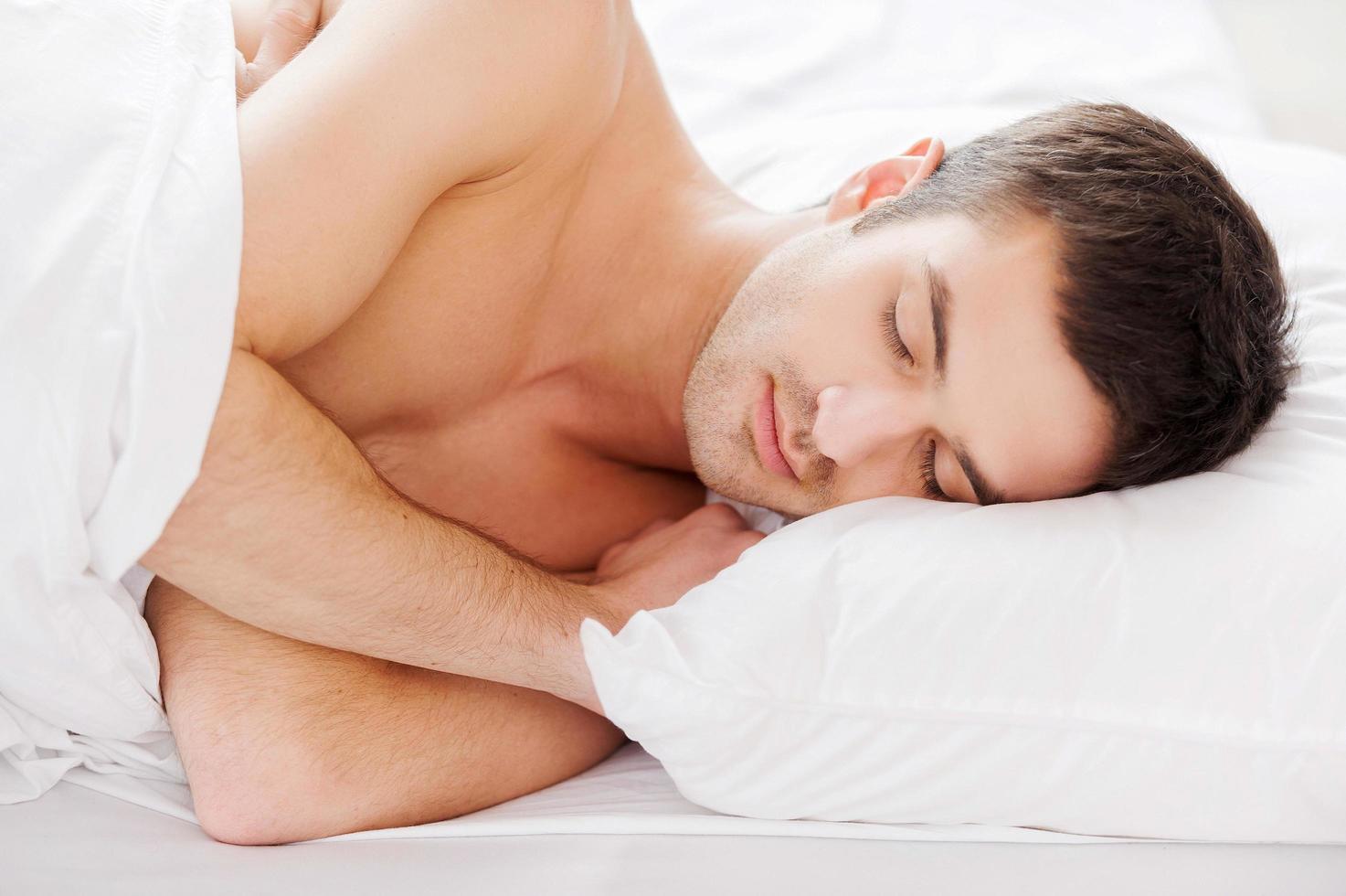 Man sleeping. Handsome young shirtless man sleeping while lying in