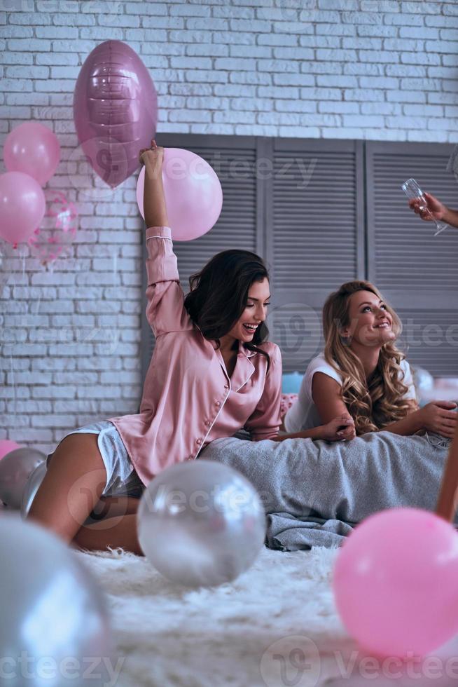 Girls only. Girlfriends in pajamas bonding together while spending time in the bedroom photo