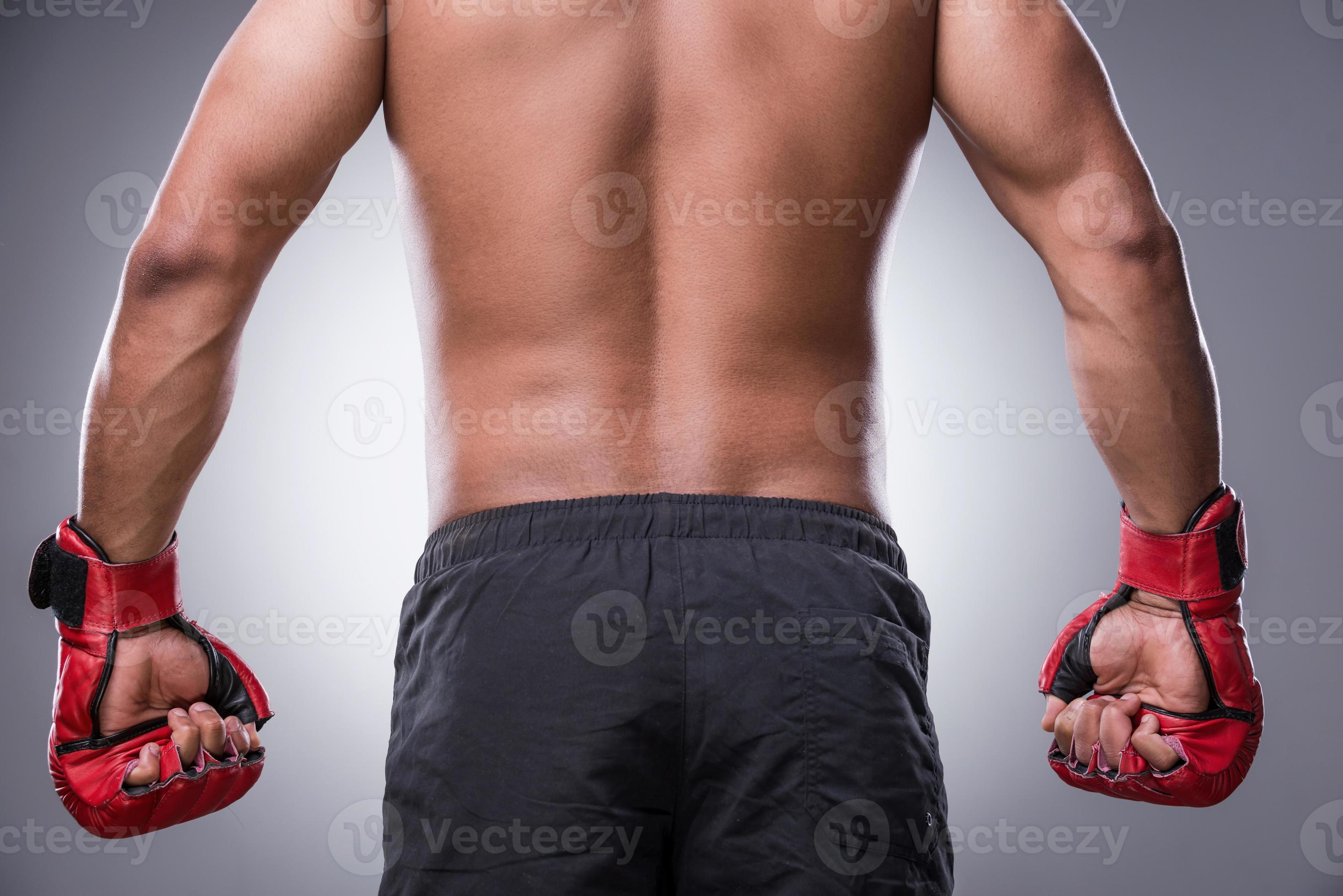 Ready to fight. Rear view of shirtless African man in boxing gloves