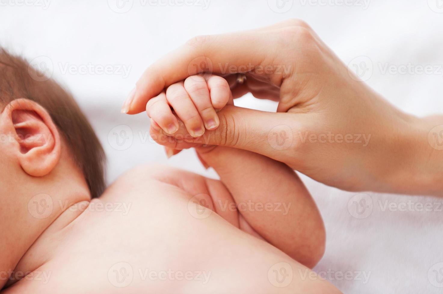 It is so tiny. Close-up of father holding a tiny hand of his little baby photo