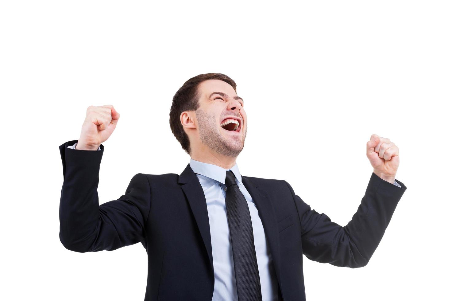 Hombre de negocios exitoso. joven feliz en ropa formal expresando positividad y gesticulando mientras está de pie aislado en blanco foto