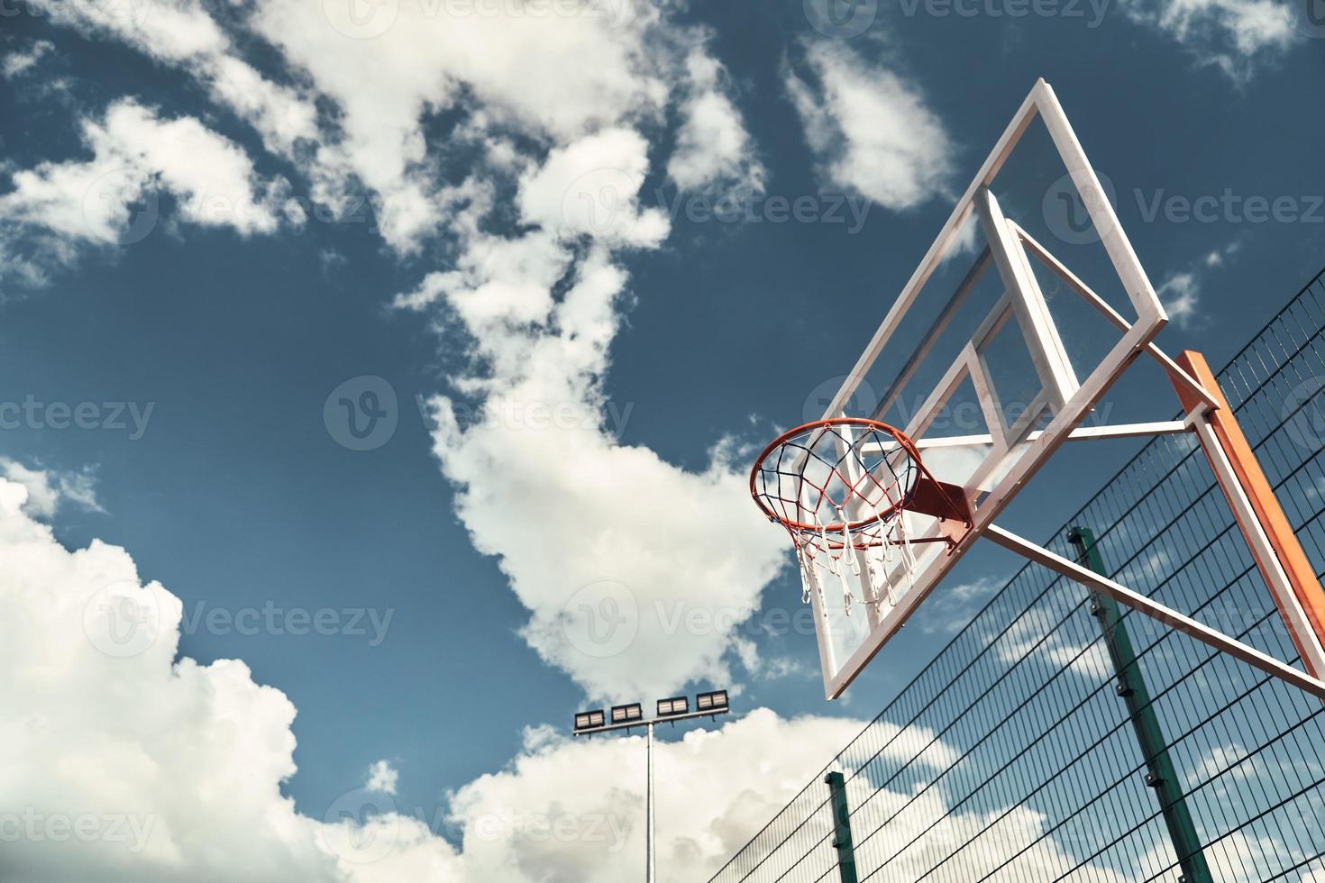 Basketball outdoors. Shot of basketball hoop with sky in the background outdoors photo