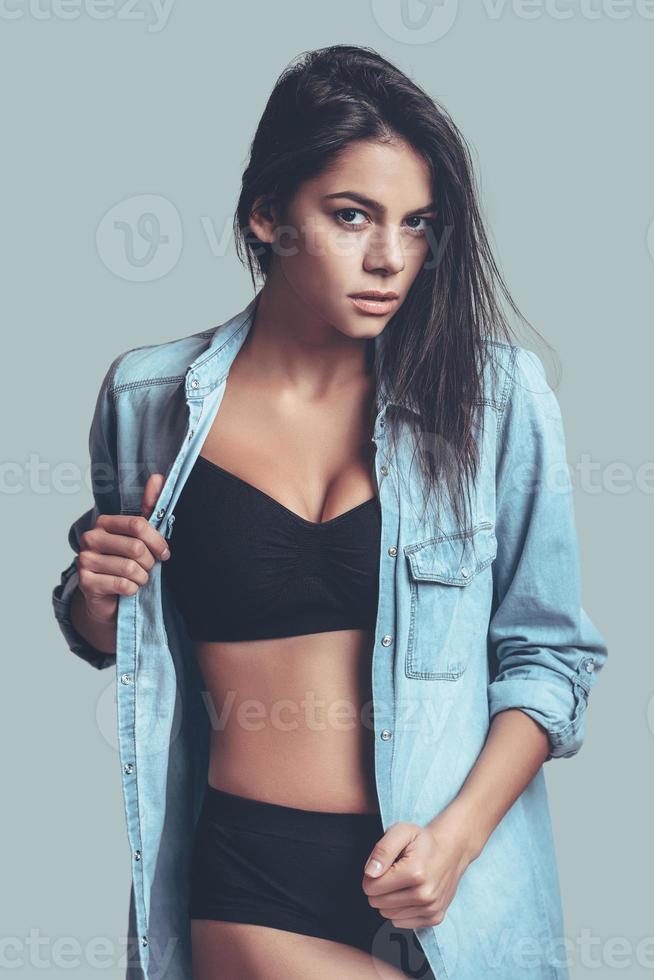 Too sexy for her shirt. Attractive young woman in underwear taking off her  T-shirt while standing in the bedroom 13579630 Stock Photo at Vecteezy