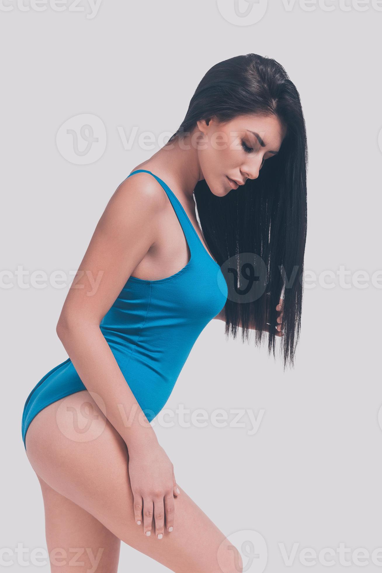 Beauty in swimsuit. Side view of attractive young woman in blue swimsuit  posing in front of grey background 13535882 Stock Photo at Vecteezy