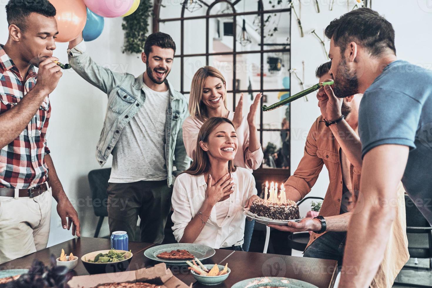 Group of young modern people taking selfie using smart phone while they having a dinner party photo