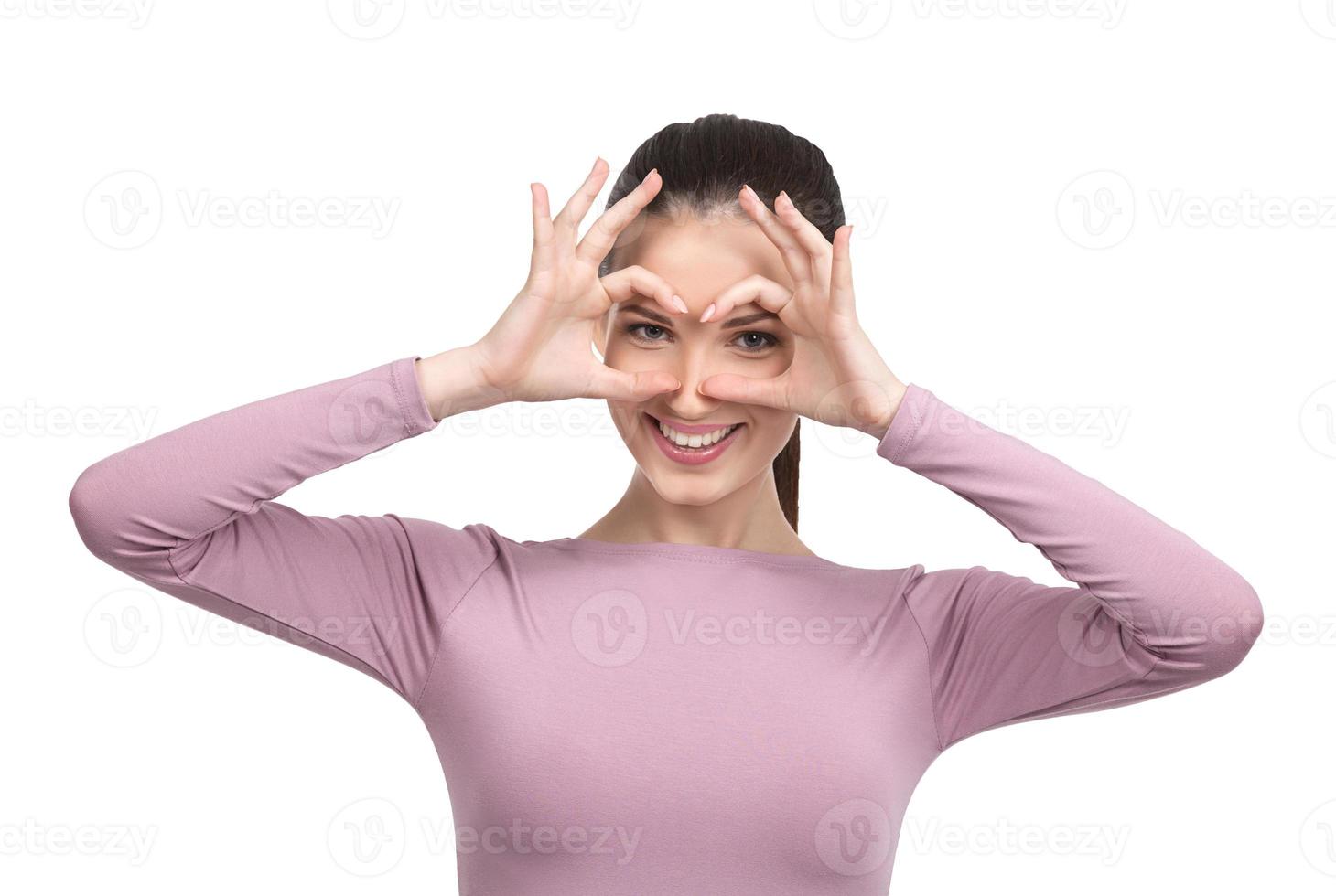 Making a face. Cheerful young woman making a face and gesturing while standing isolated on white photo