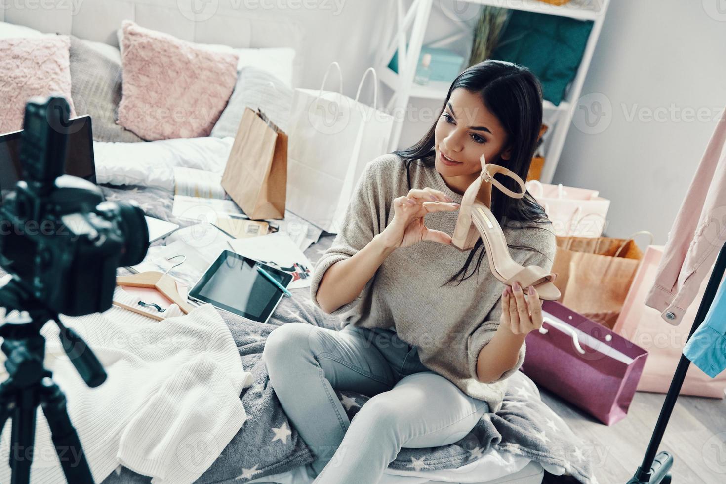 Beautiful young woman in casual clothing making social media video while spending time at home photo