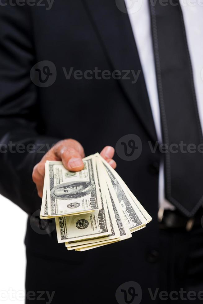 This is for you. Close-up of businessmen stretching out hand with money photo