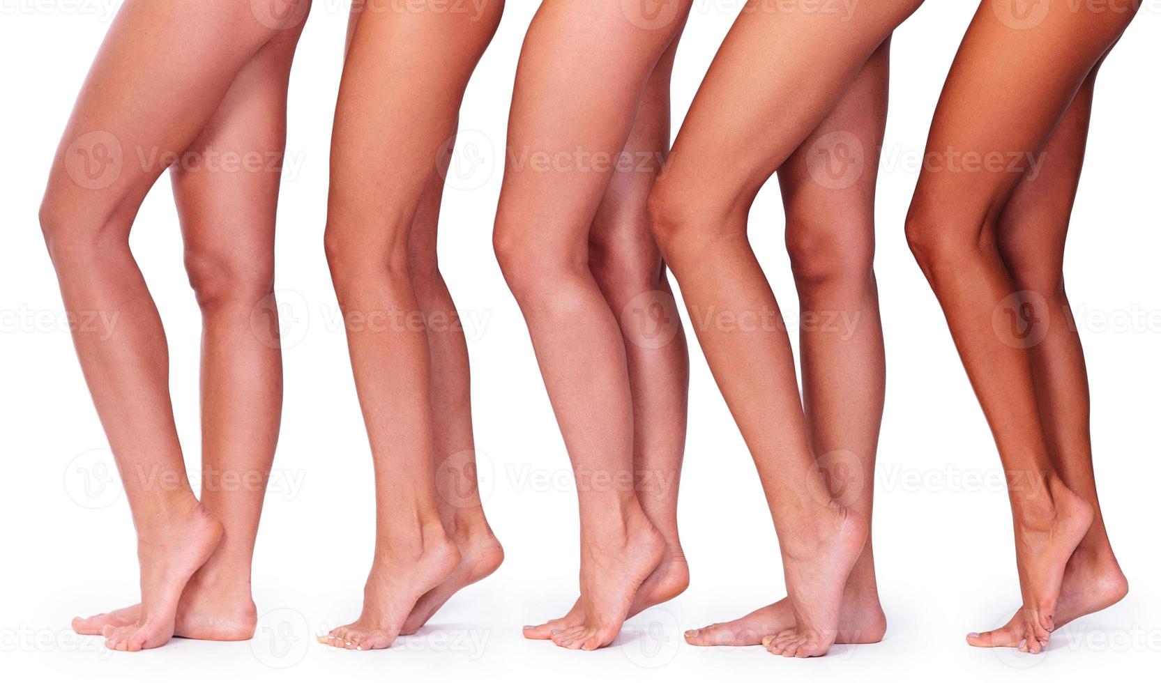 Perfect legs. Close-up side view of five beautiful women showing their perfect legs while standing against white background photo