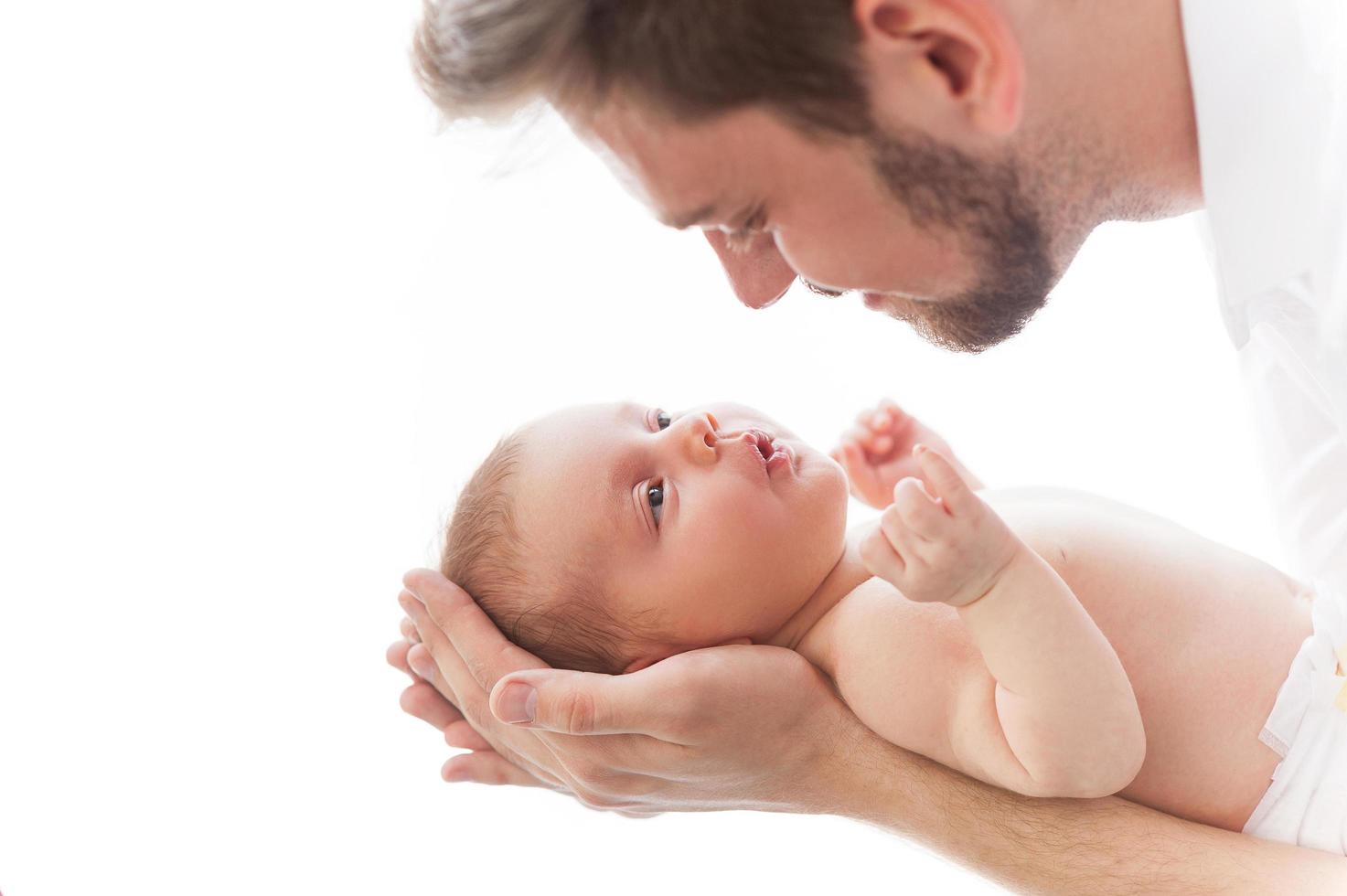 Father and baby. Close-up of father holding cute little baby in hands and smiling photo