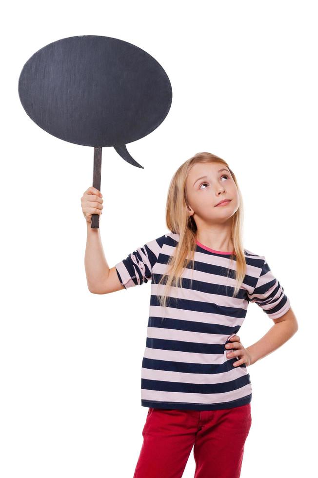 pensando en... niña pensativa sosteniendo un espacio de copia y mirando hacia otro lado mientras está de pie aislado en blanco foto