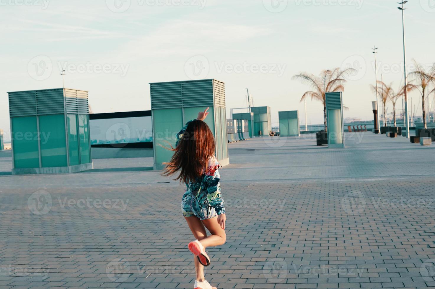 Attractive young woman feeling free while running outdoors photo