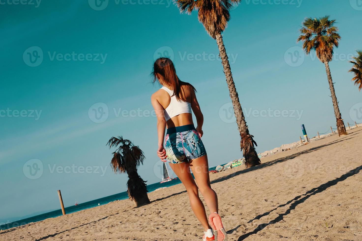 Nice day for training. Rear view of beautiful young woman in sports clothing jogging while exercising outdoors photo