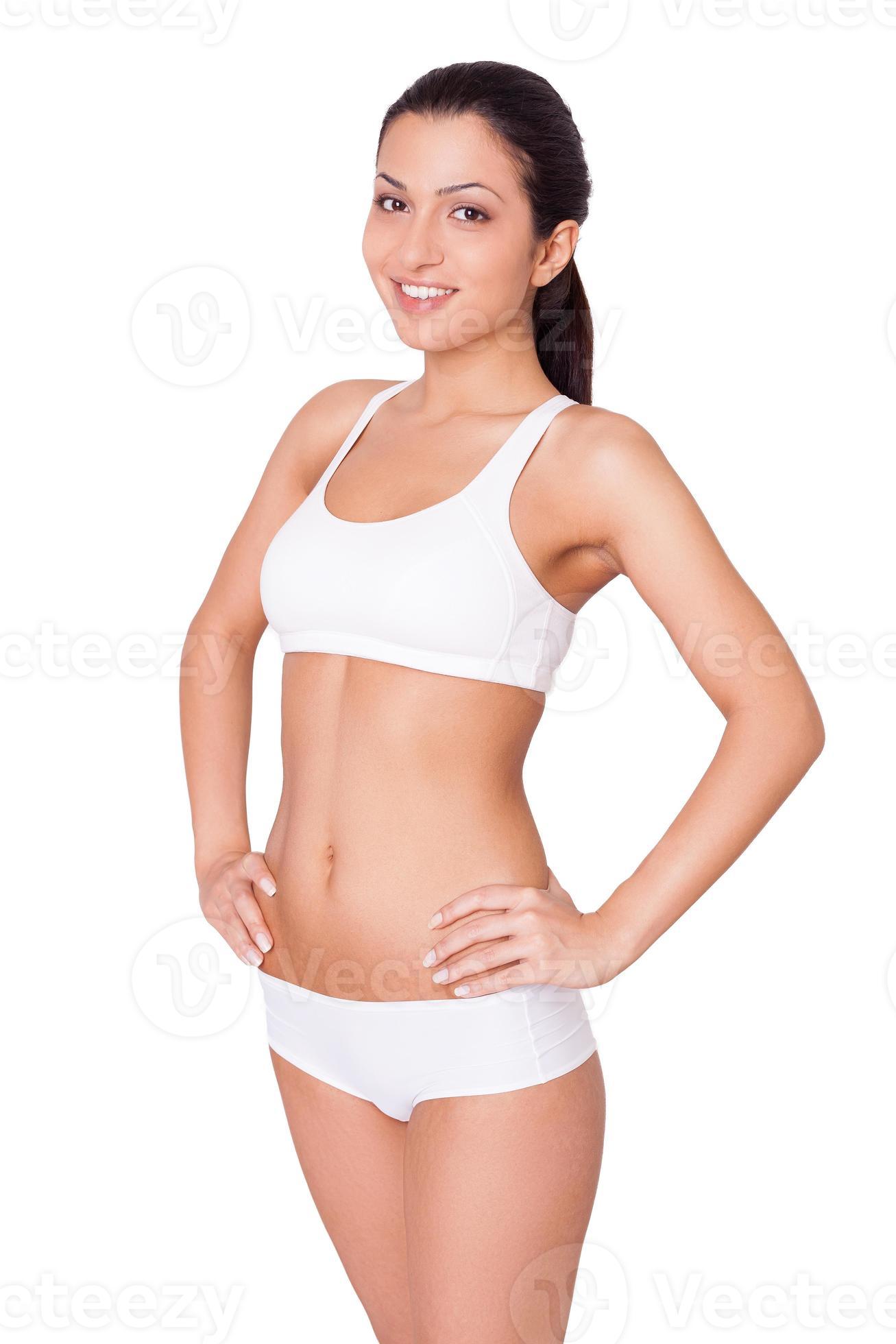 Young and healthy. Attractive young Indian woman in white bra and panties  holding hands on hip and smiling at camera while standing isolated on white  13538649 Stock Photo at Vecteezy