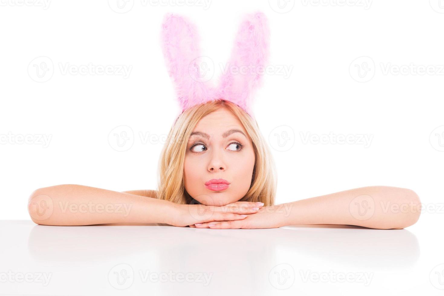 The cutest Easter bunny. Beautiful young blond hair woman with rabbit ears leaning at the copy space and looking away photo