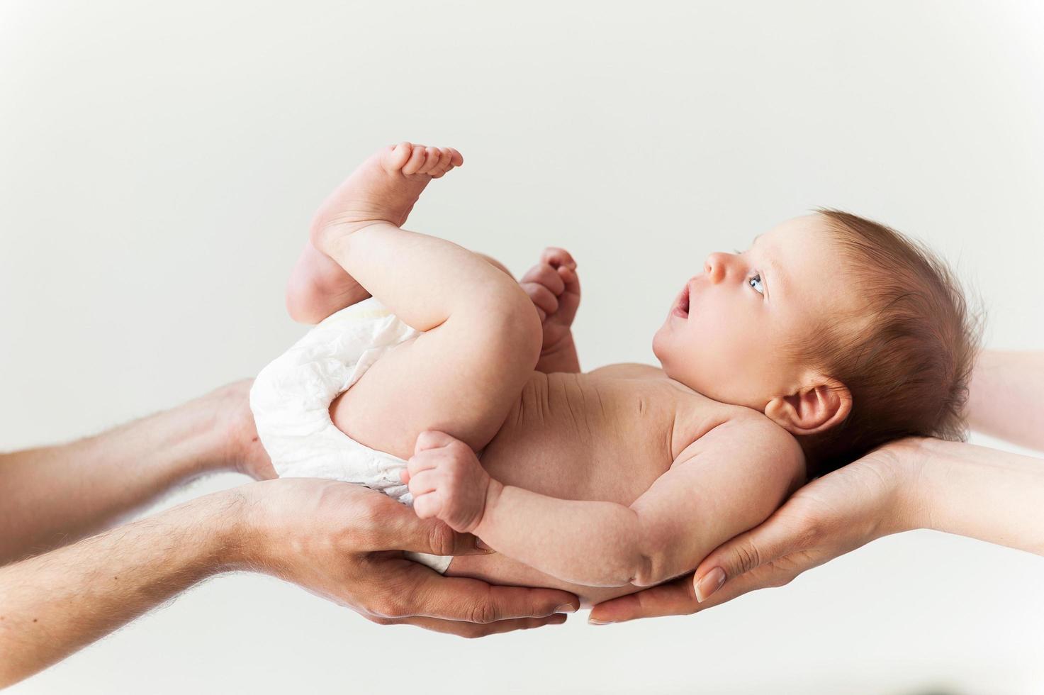 Parents with baby. Close-up of mothers and fathers hands holding cute little baby photo