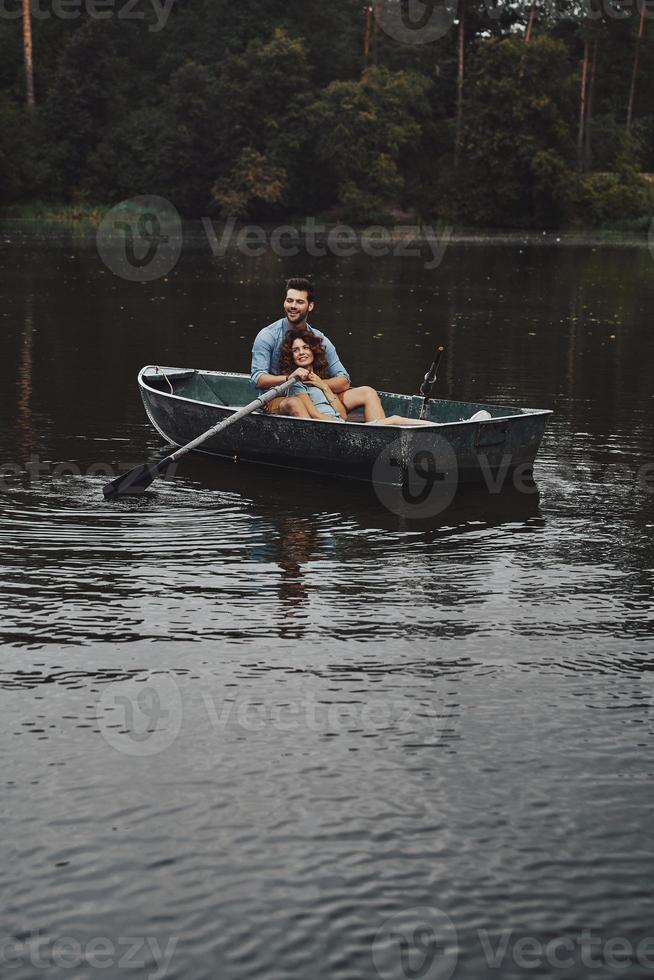 Life can not be better. Beautiful young couple embracing and smiling while enjoying romantic date on the lake photo