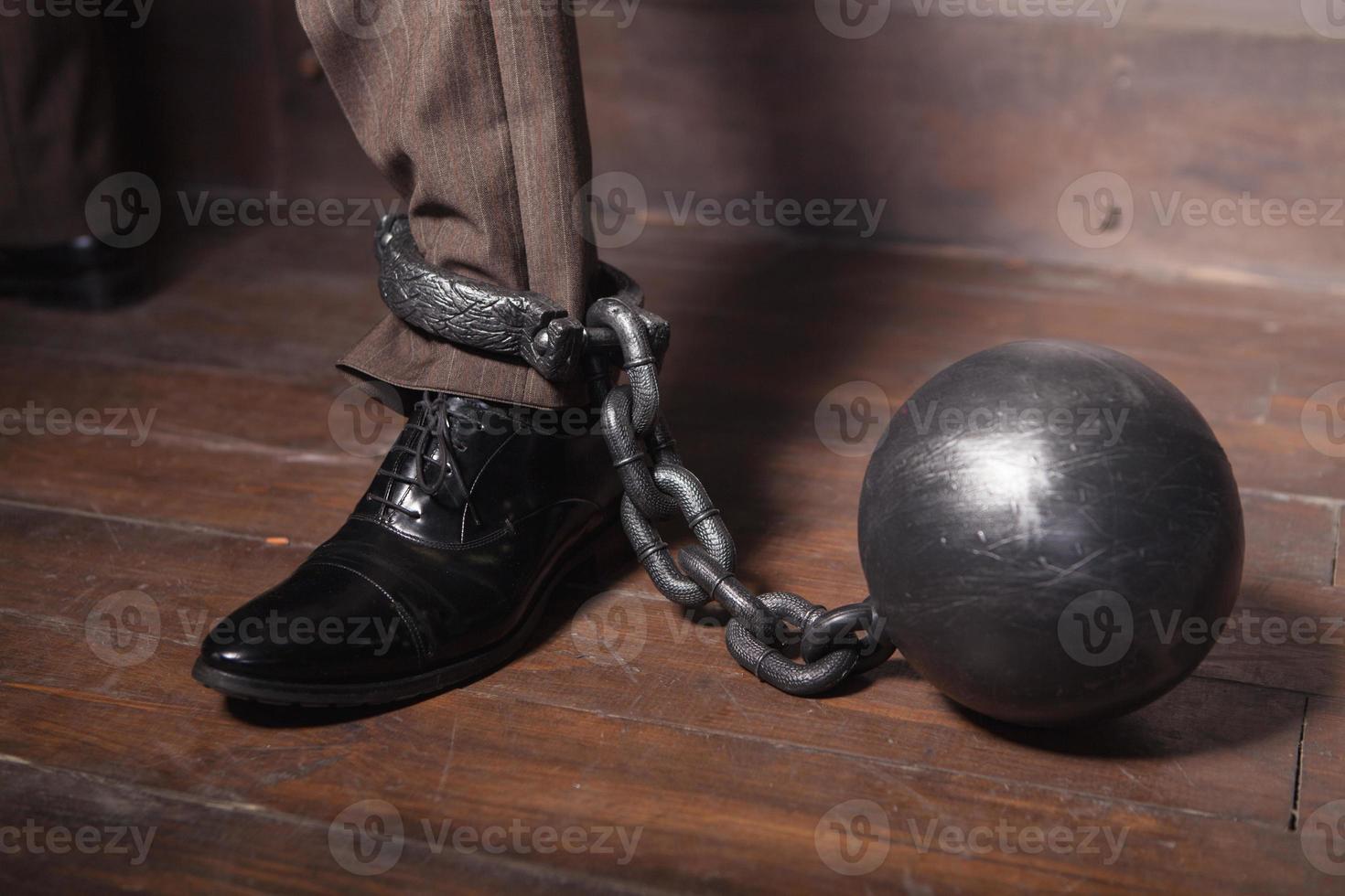 Shackles on his hand. Top view of businessman leg with shackles on it photo