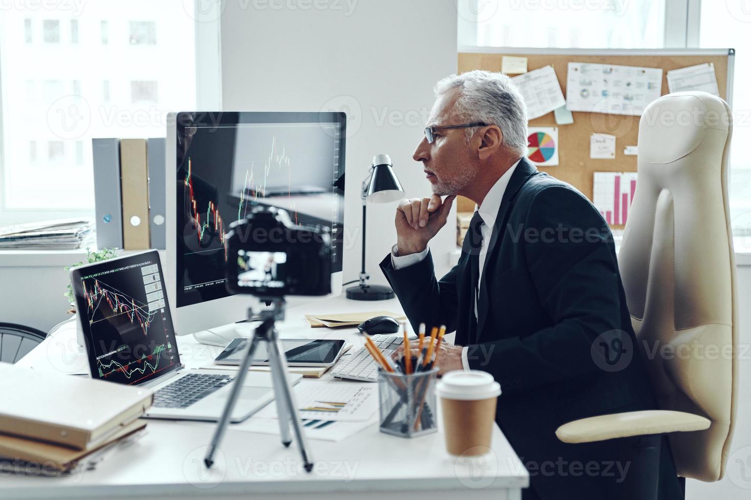 Senior man in elegant business suit using modern technologies while making social media video photo