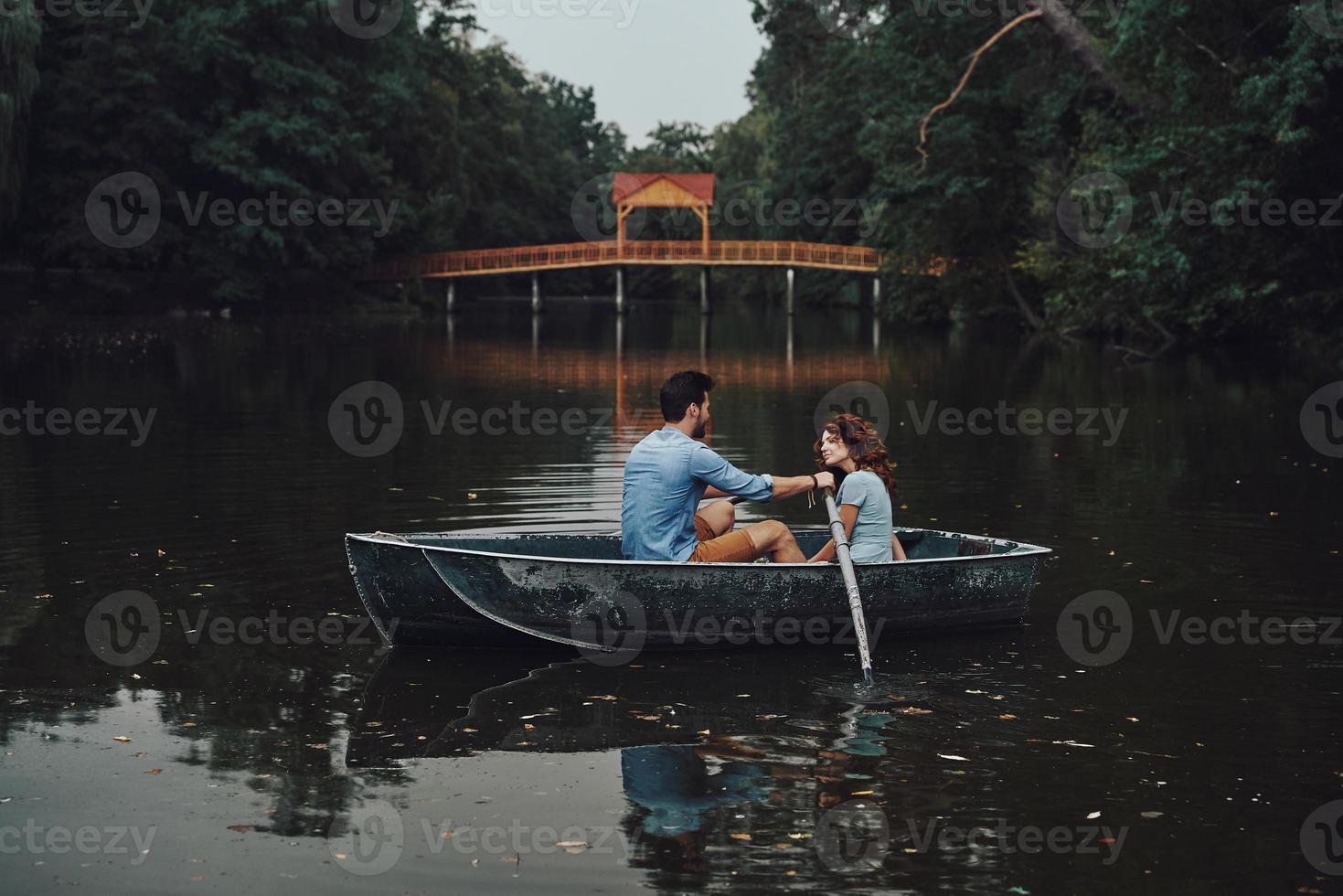 Two hearts full of love. Beautiful young couple smiling while enjoying romantic date on the lake photo