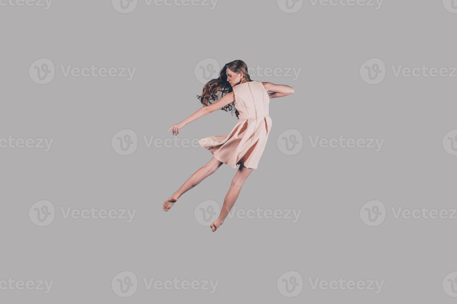 In the air. Studio shot of attractive young woman hovering in air photo