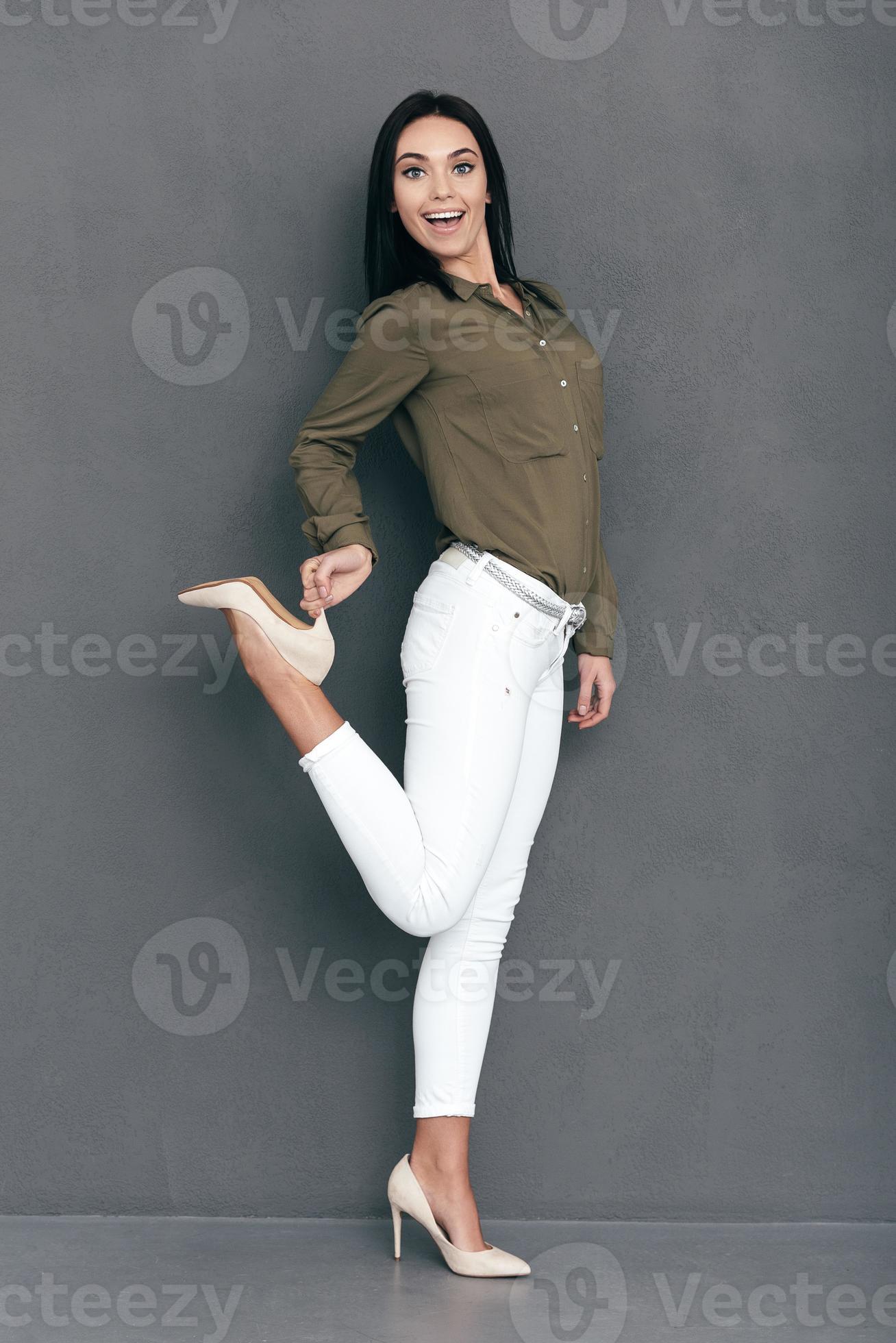 Look at my new heels Full lenght of attractive young woman in smart casual  wear posing against grey background and looking happy 13546260 Stock Photo  at Vecteezy