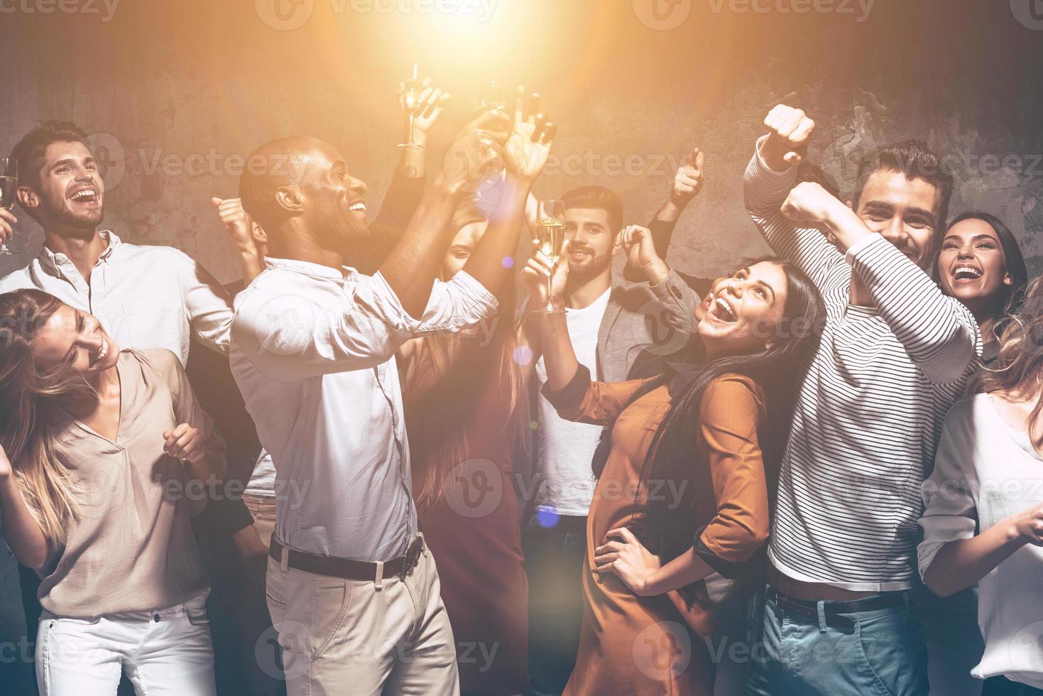 son imparables. grupo de hermosos jóvenes bailando juntos y luciendo felices foto