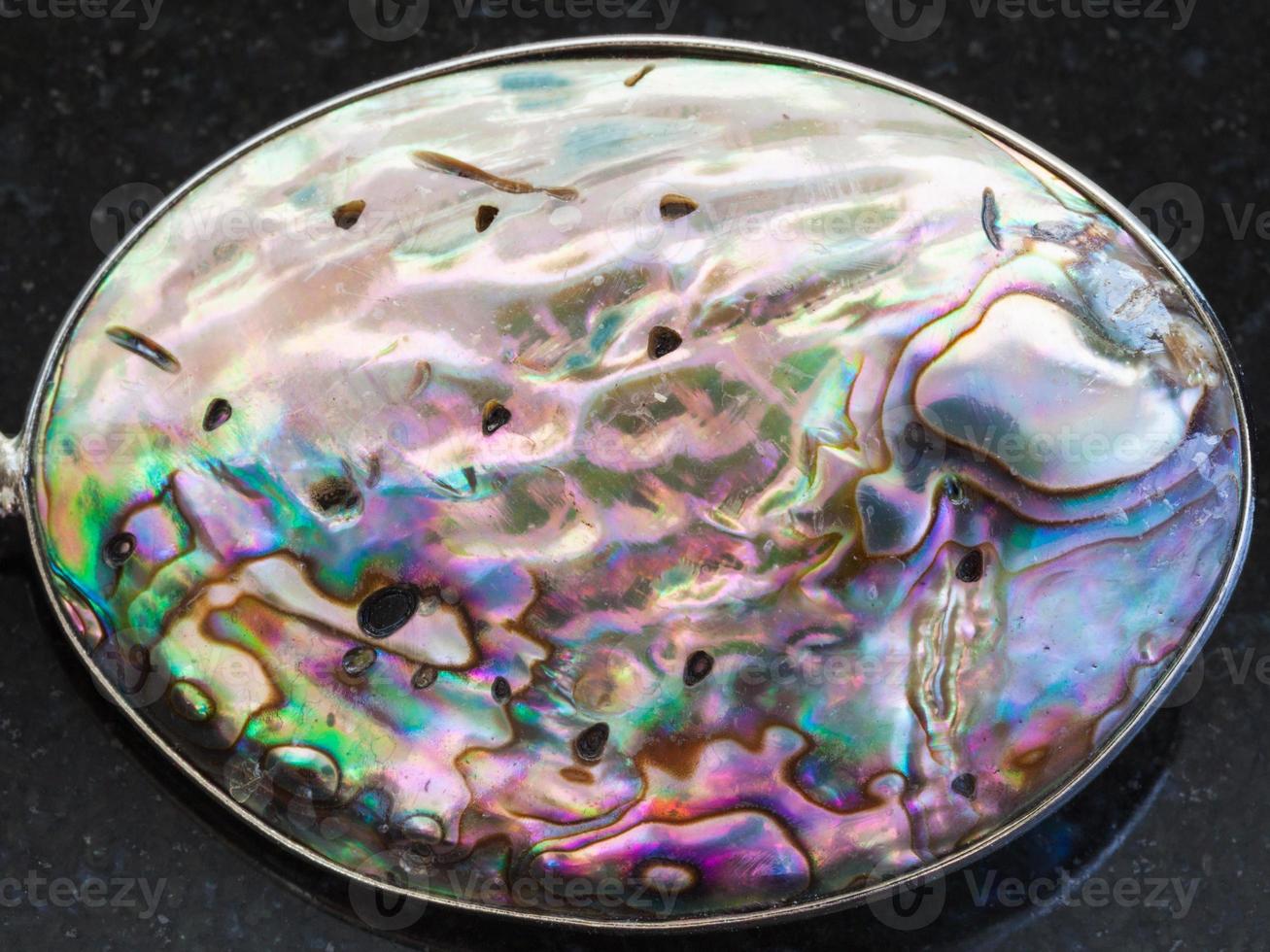 cabochon from Abalone haliotis shell on dark photo