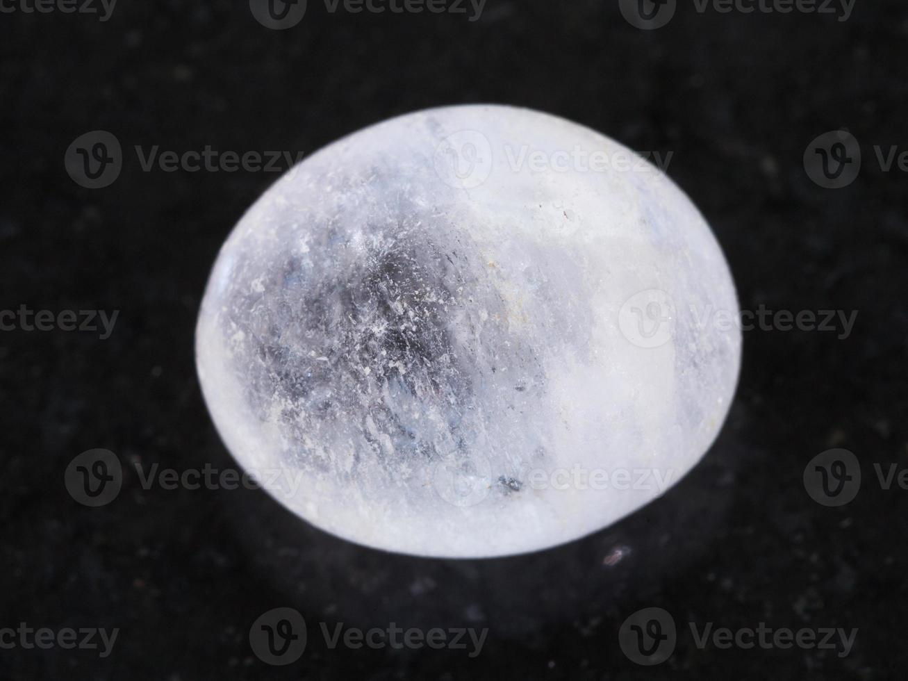polished white agate gemstone on dark photo