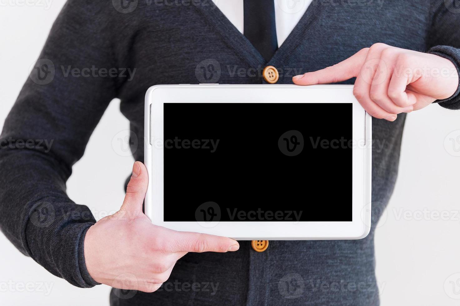 Join a digital age Cropped image of man in formalwear holding a digital tablet while standing against grey background photo