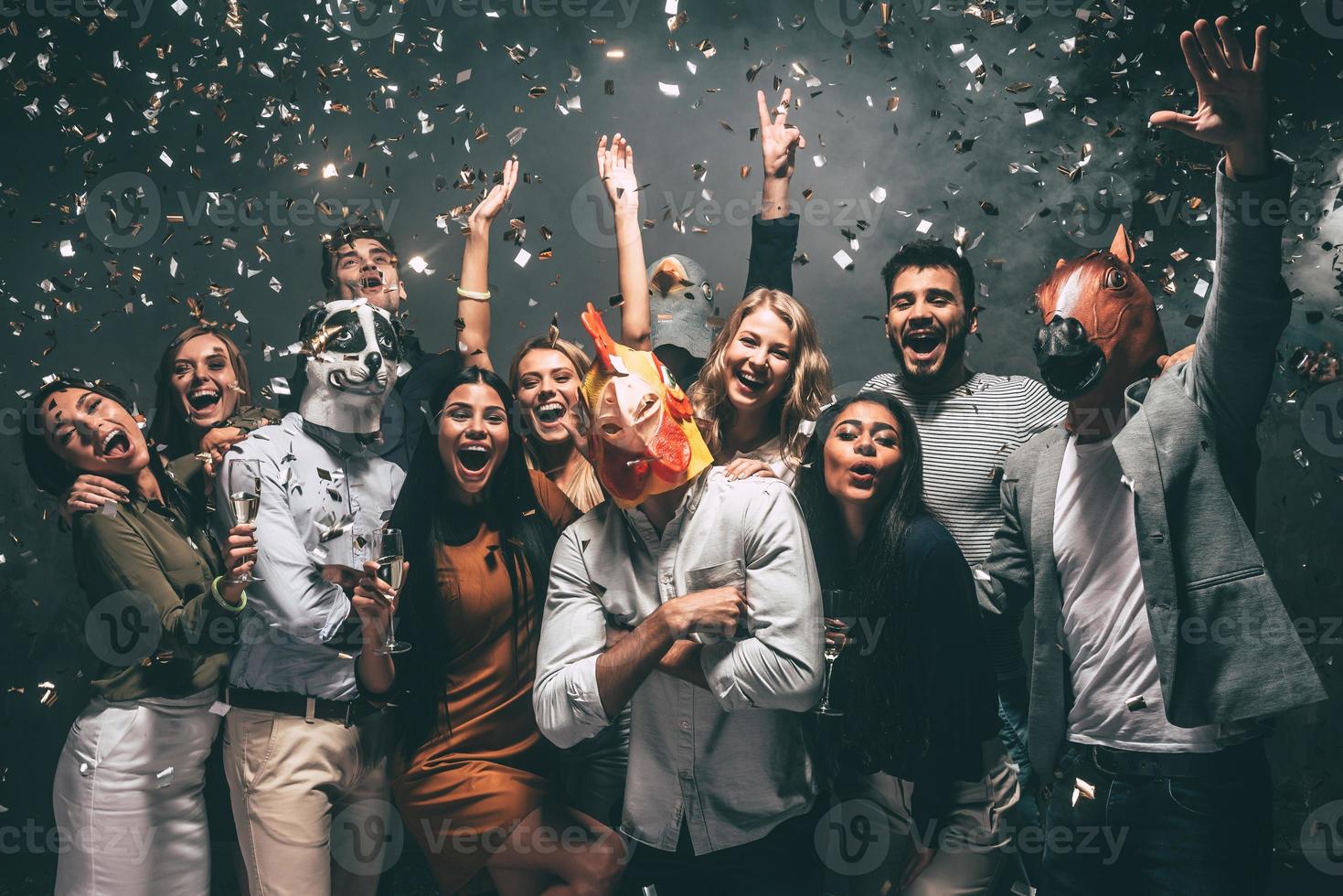 este es mi año grupo de jóvenes con máscaras de animales tirando confeti y luciendo felices foto