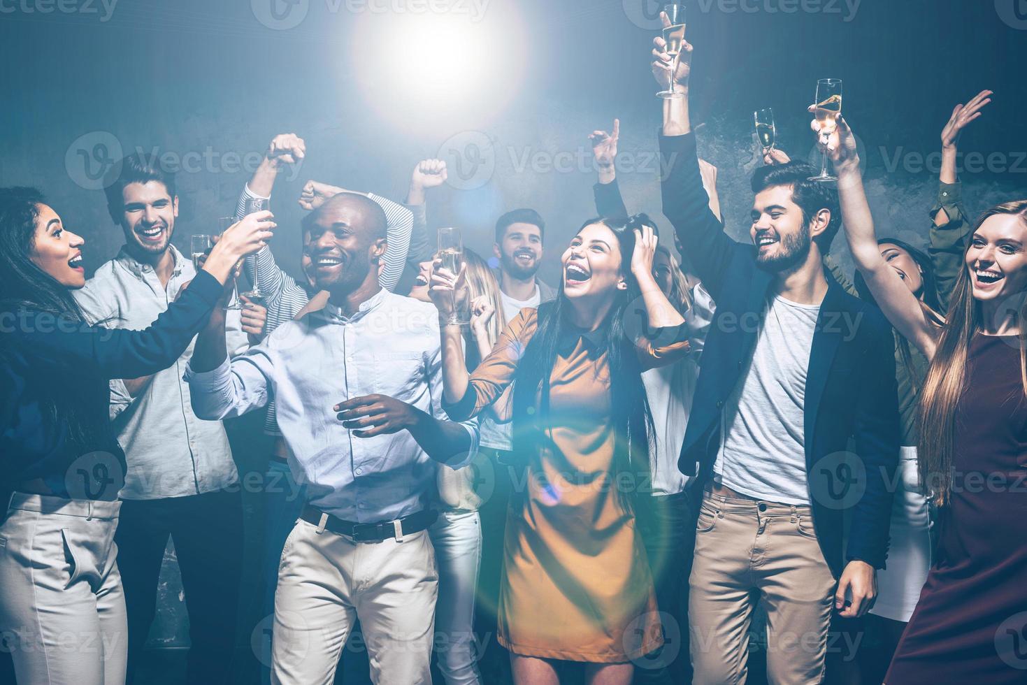 Party with friends. Group of beautiful young people dancing together and looking happy photo