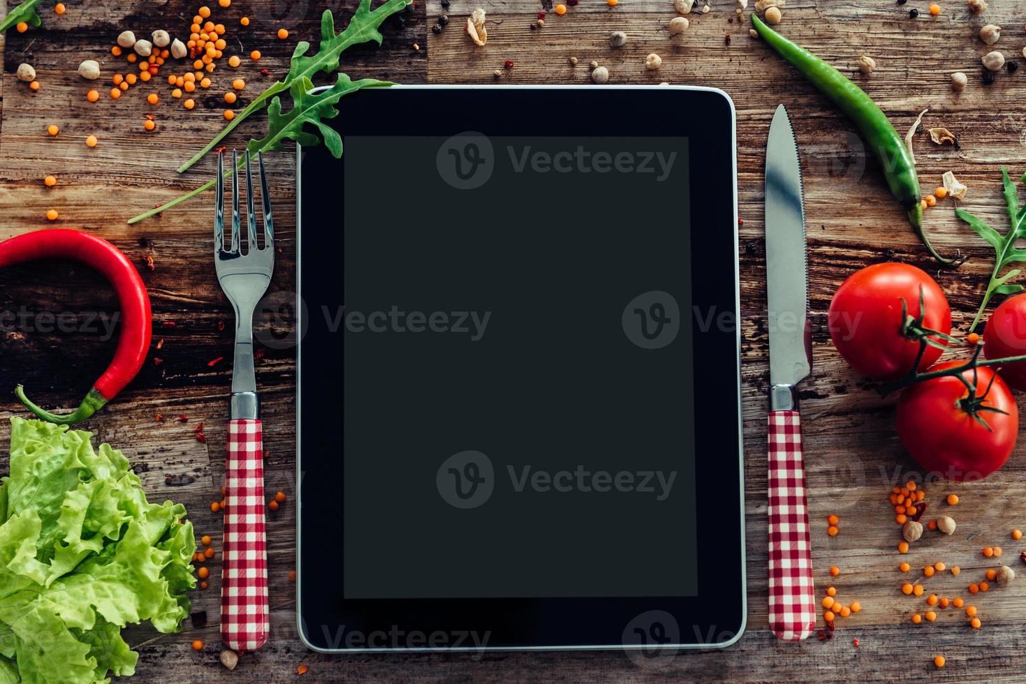 What we got today Top view of digital tablet laying on the wooden dining table with vegetables around photo