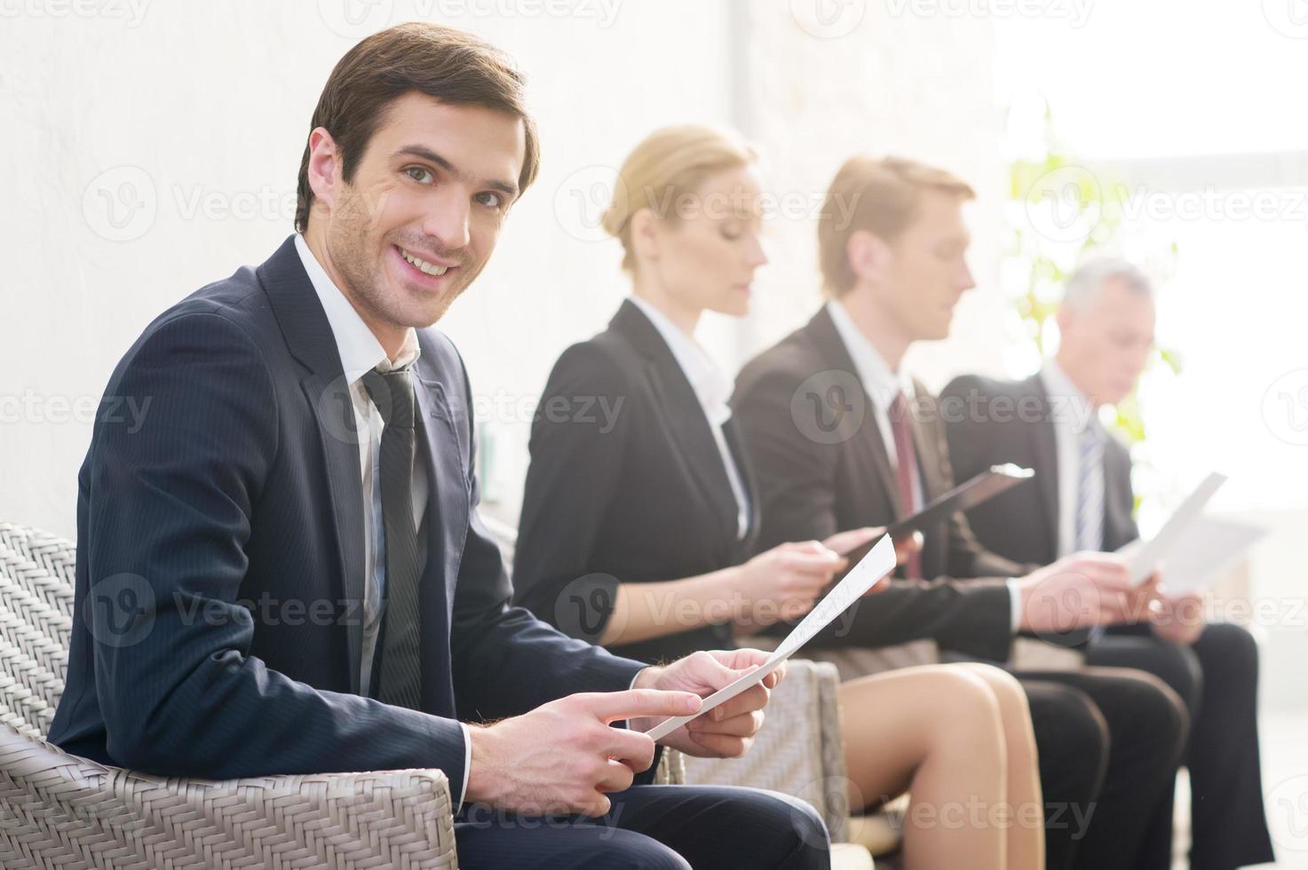 I will get this job Four people in formalwear waiting in line while one of them looking at camera and smiling photo