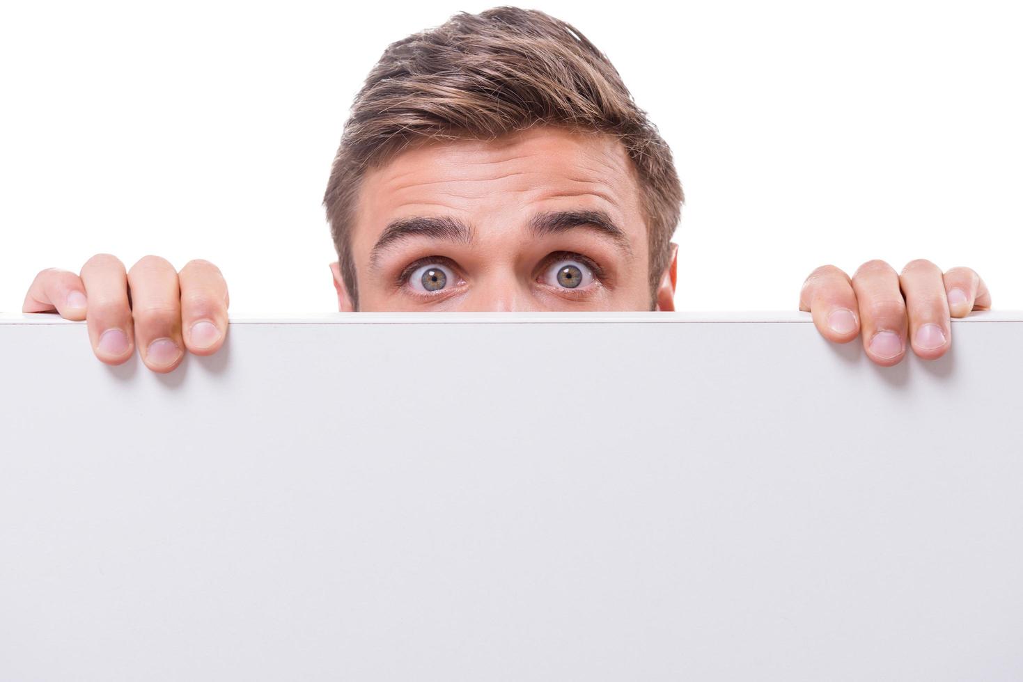 Terrified man. Shocked young man looking out of the copy space while being isolated on white photo