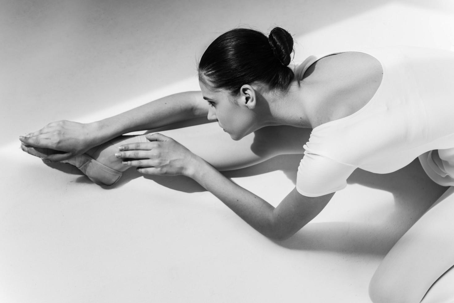 Working hard to be the best. Top view of beautiful young ballerina doing stretching exercises photo