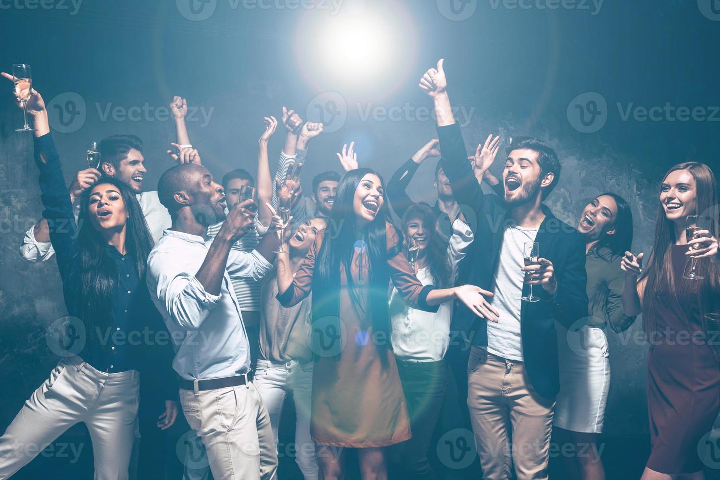 diversión es todo lo que necesitamos un grupo de hermosos jóvenes bailando juntos y luciendo felices foto