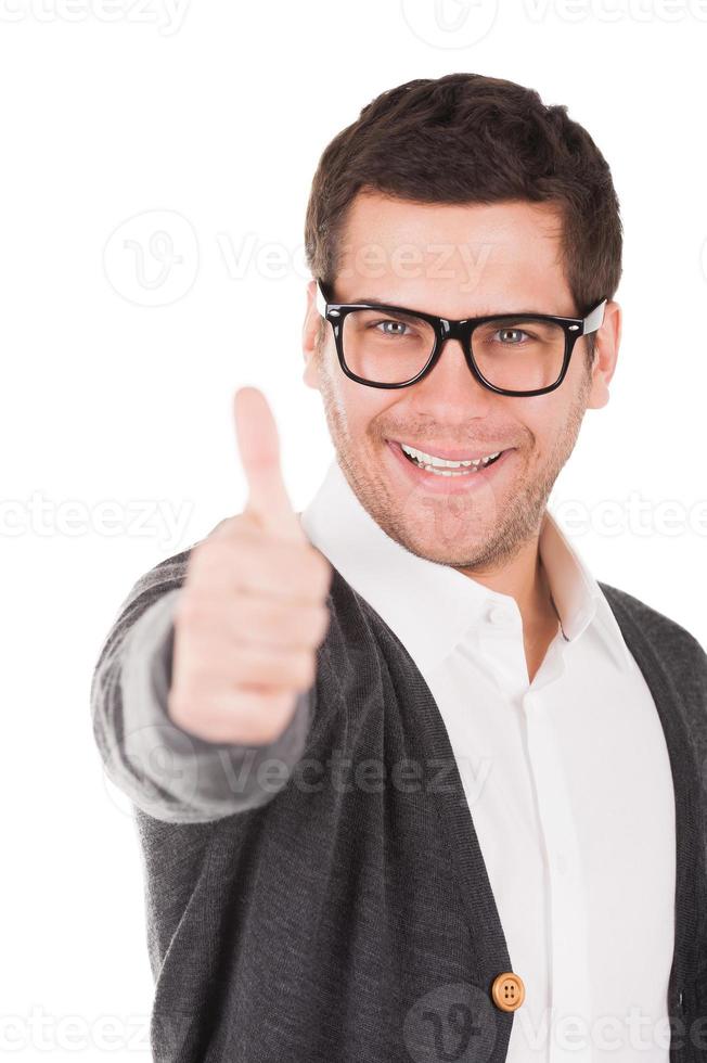 Everything is good Handsome young man holding showing his thumb up and smiling while standing isolated on white photo