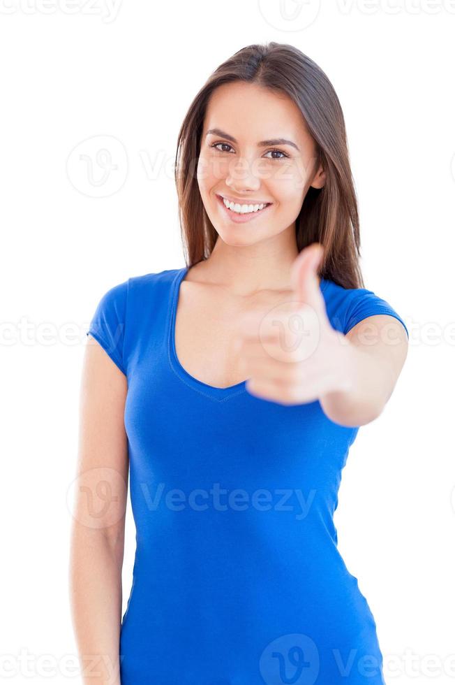 Everything is all right Beautiful young smiling woman looking at camera and gesturing while standing isolated on white photo