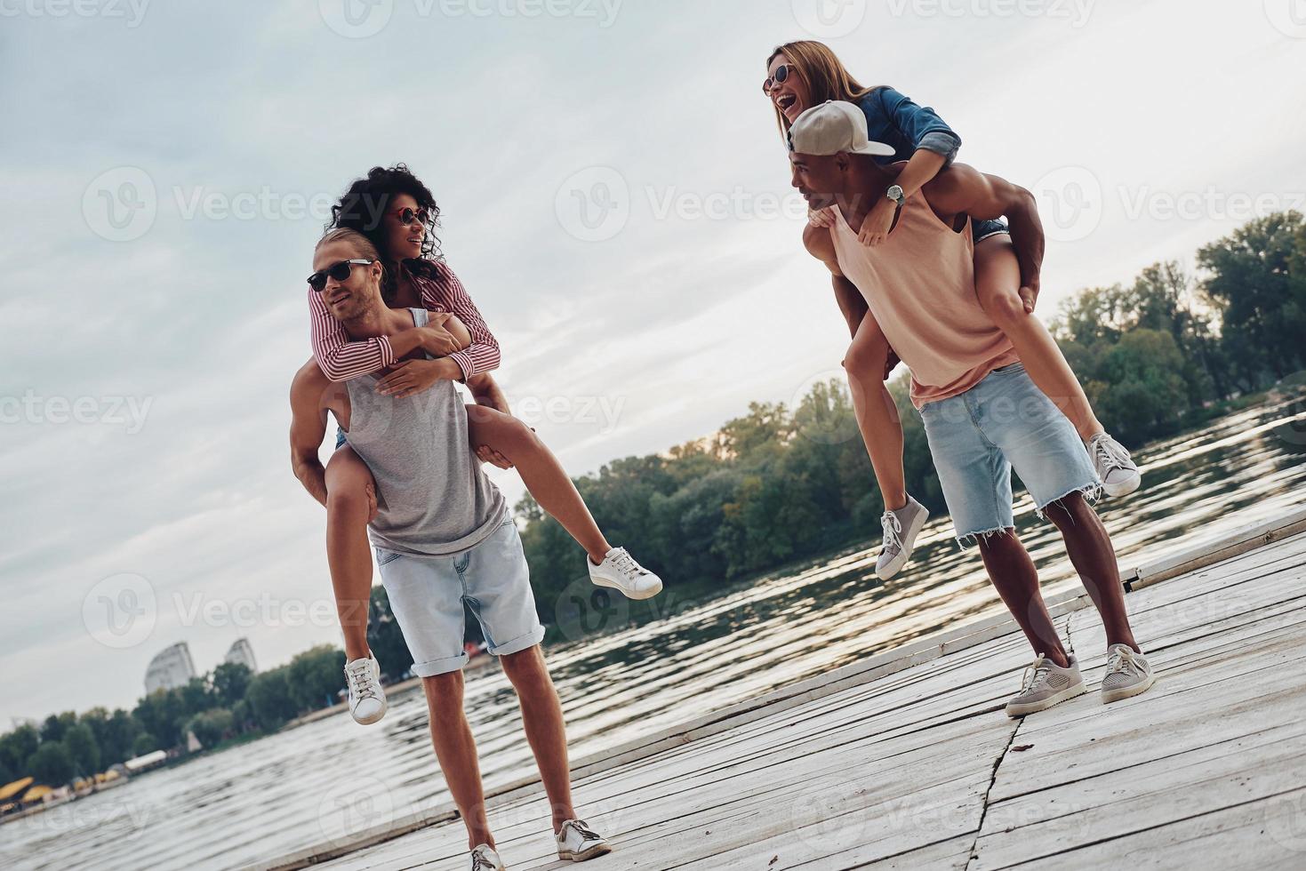 Spending carefree time. Beautiful young couples spending carefree time while standing on the pier photo
