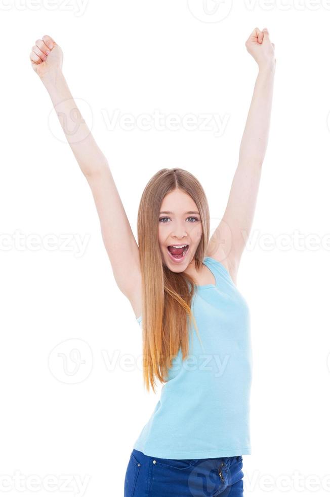 Young winner Happy teenage girl keeping arms raised while standing isolated on white photo
