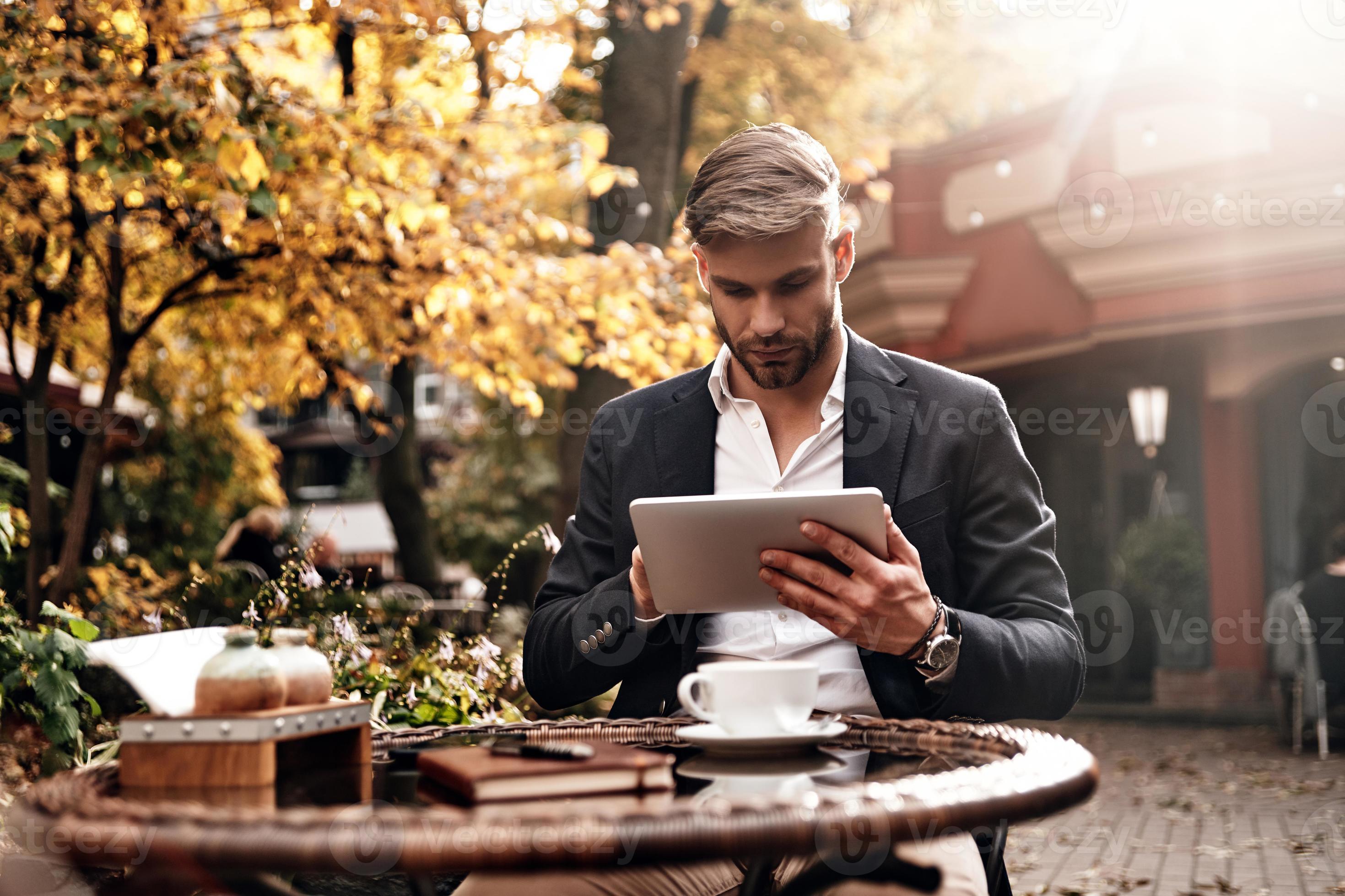 Always online. Good looking young man in smart casual wear using