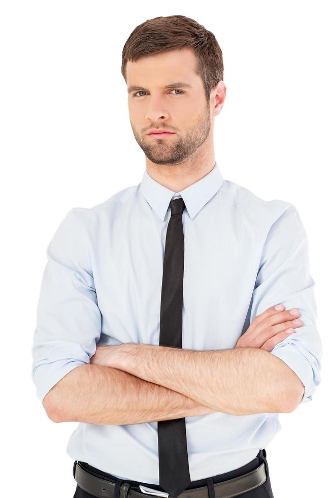 Young and successful. Handsome young man in shirt and tie looking at camera and keeping arms crossed while standing isolated on white background photo